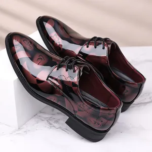 Gros plan de chaussures de ville pour hommes à motifs floraux bordeaux sur marbre
