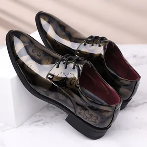 Détail de chaussures de ville pour hommes brillantes avec motif floral et lacets