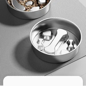 Gros plan d'une gamelle anti-glouton en inox pour animaux avec des motifs d'os