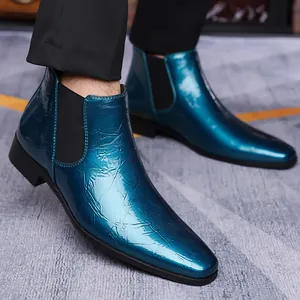 Vista detallada de los botines Chelsea de cuero brillante verde azulado con grietas