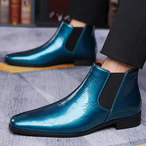 Primer plano de botas Chelsea azul metálico con textura arrugada y paneles elásticos