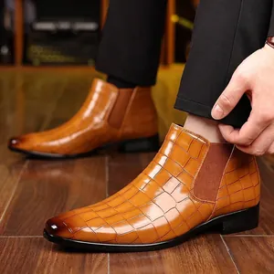 Close-up van bruine Chelsea boots voor heren met een stijlvol krokodillenpatroon