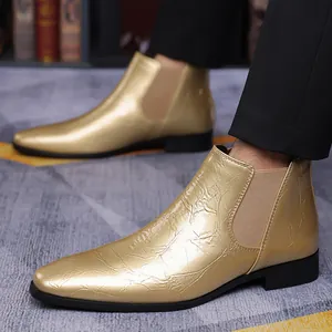 Detalle de botines Chelsea dorados para hombre con punta afilada y elástico lateral