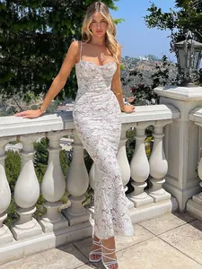 Robe longue en dentelle florale blanche portée par un mannequin dans un cadre extérieur.