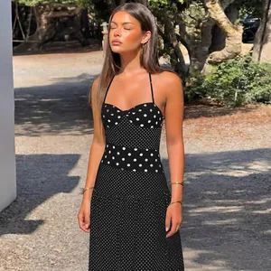 Dettaglio di un abito a pois bianco e nero con scollatura all'americana.