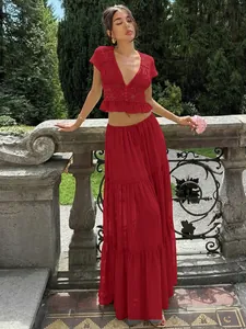 Κομψό σετ κόκκινο δαντελωτό crop top και σιφόν μάξι φούστα σε έναν όμορφο κήπο