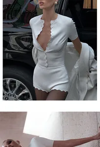 Detail view of a chic white scalloped single-breasted knit top and matching shorts set