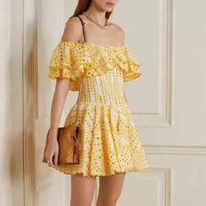 Detailansicht eines gelb-weißen bestickten Off-Shoulder-Minikleides mit Rüschen