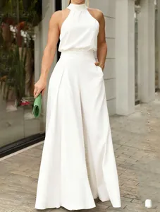 Detailed view of an elegant white halter neck wide-leg jumpsuit worn by a model outdoors