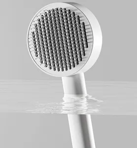 Detailed close-up of a white pet slicker brush with fine needles in clear water.