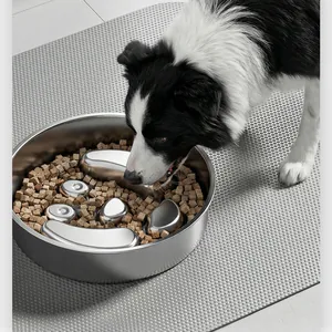 Gros plan d'un border collie mangeant dans une gamelle anti-glouton en acier inoxydable