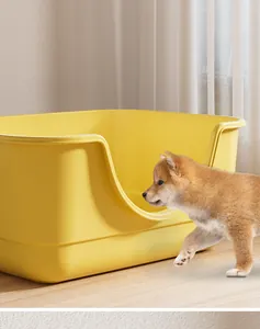 Detail of large yellow pet litter box featuring a low entry design for easy access for puppies.