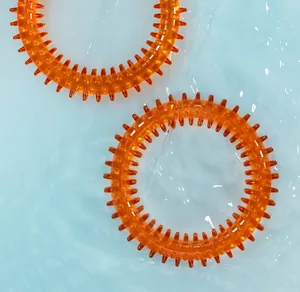 Macro-detail van oranje doorschijnende bijtringen voor huisdieren op blauwe waterachtergrond