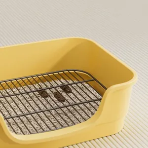 Gelbe Hundetoilette mit schwarzem Metallgitter für saubere Pfoten