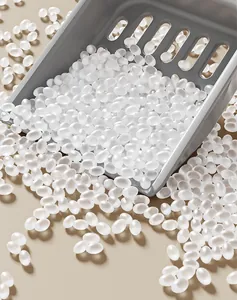 Close-up of translucent absorbent pellets for dog litter trays with a gray scoop