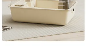 Close-up detail view of a luxury large cream-colored hamster cage on a textured rug.