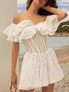 Detailaufnahme eines weißen, schulterfreien Mini-Kleides mit Stickerei für Frühling