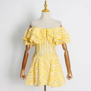 Nahaufnahme eines gelben bestickten Kleides mit gerüschtem Off-Shoulder-Design.