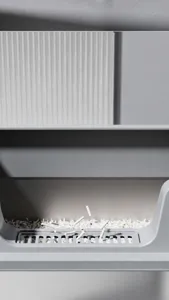 Close-up of the sand-filtering pedal on a large grey stainless steel cat litter box.