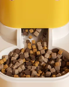 Detailopname van dierenvoeding die in een moderne gele automatische voerbak valt