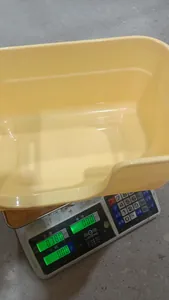 Vista macro del arenero para gatos amarillo pálido pesado en báscula digital con 0,380 kg
