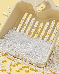 Close-up of cream butterfly cat litter scoop with white silica pellets on yellow background