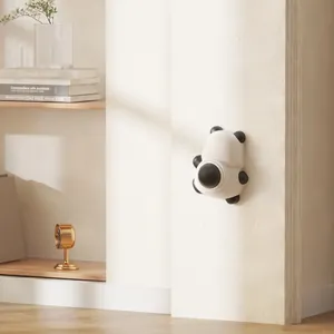 Jouet à l'herbe à chat mural en forme de panda présenté dans un décor intérieur minimaliste