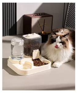 Detalle del dispensador automático de agua y comida para mascotas con un gato presente