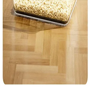 Nahaufnahme einer transparenten spritzgeschützten Katzenstreumatte auf Holzboden.