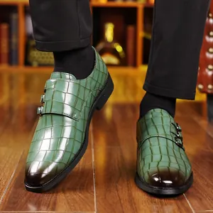 Dettaglio di scarpe in pelle verde da uomo con motivo a coccodrillo, fibbie e punta