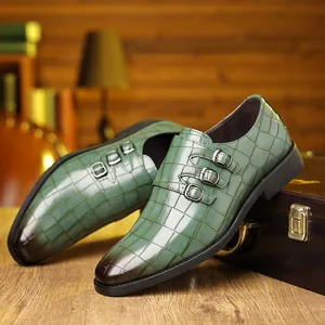 Primo piano di eleganti scarpe in pelle verde motivo coccodrillo con tripla fibbia argento