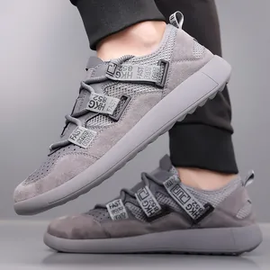 Detailed view of grey thick-sole retro sneakers with mesh panels and strap details