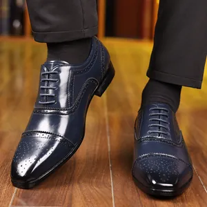 Detailed shot of navy blue Brogue dress shoes with intricate carved wingtip patterns.