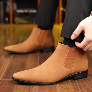 Gros plan de bottines Chelsea élégantes en daim marron avec un bout pointu pour hommes.