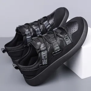 Close-up of black chunky dad shoes featuring mesh panels and decorative straps.