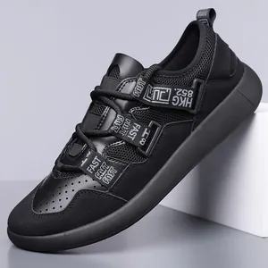 Side profile of black retro chunky sneakers with decorative letter straps and mesh panels.