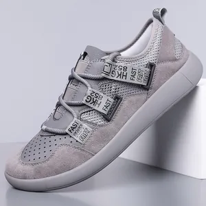 Side view of gray thick-sole retro sneakers with mesh and suede texture details.