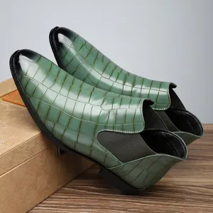 Detailed macro view of men's green crocodile pattern Chelsea boots with a black gradient toe.