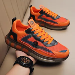 Dettaglio di scarpe sportive arancioni e nere con inserti in tessuto a rete mesh