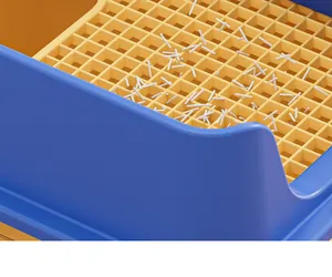 Primer plano de caja de arena azul con rejilla de tamizado amarilla para evitar rastro