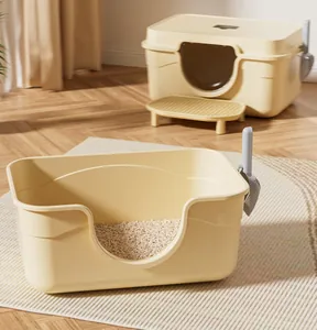 Open and semi-enclosed large cream cat litter boxes with scoop in a sunny home setting