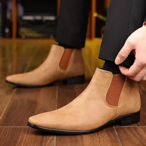 Détail de bottines Chelsea pour hommes à bout pointu ocre sur un sol en bois massif