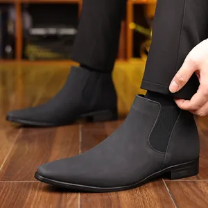 Détail de bottines Chelsea pour hommes en cuir noir mat avec bout pointu et élastiques.