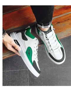 Primo piano di eleganti sneakers alte bianche con dettagli patchwork verdi e grigi