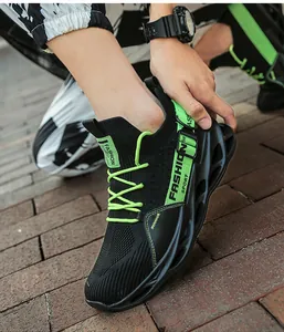 Vue détaillée des baskets blade en maille flyknit noire et vert fluo pour hommes sur le pavé.