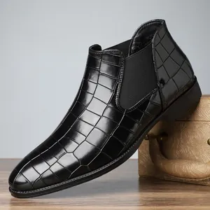 Detailed side view of men's black Chelsea boots with embossed crocodile texture.