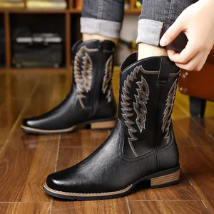 Close-up of stylish black western cowboy boots featuring detailed embroidery on the shaft