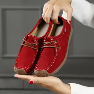 Gros plan détaillé de mocassins en daim rouge vif pour femmes avec surpiqûres blanches