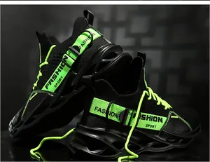 Gros plan de baskets à lame en tricot noir avec accents et lacets vert fluo vifs.