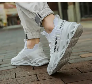 Vue détaillée de baskets blanches en maille respirante pour hommes sur pavé urbain